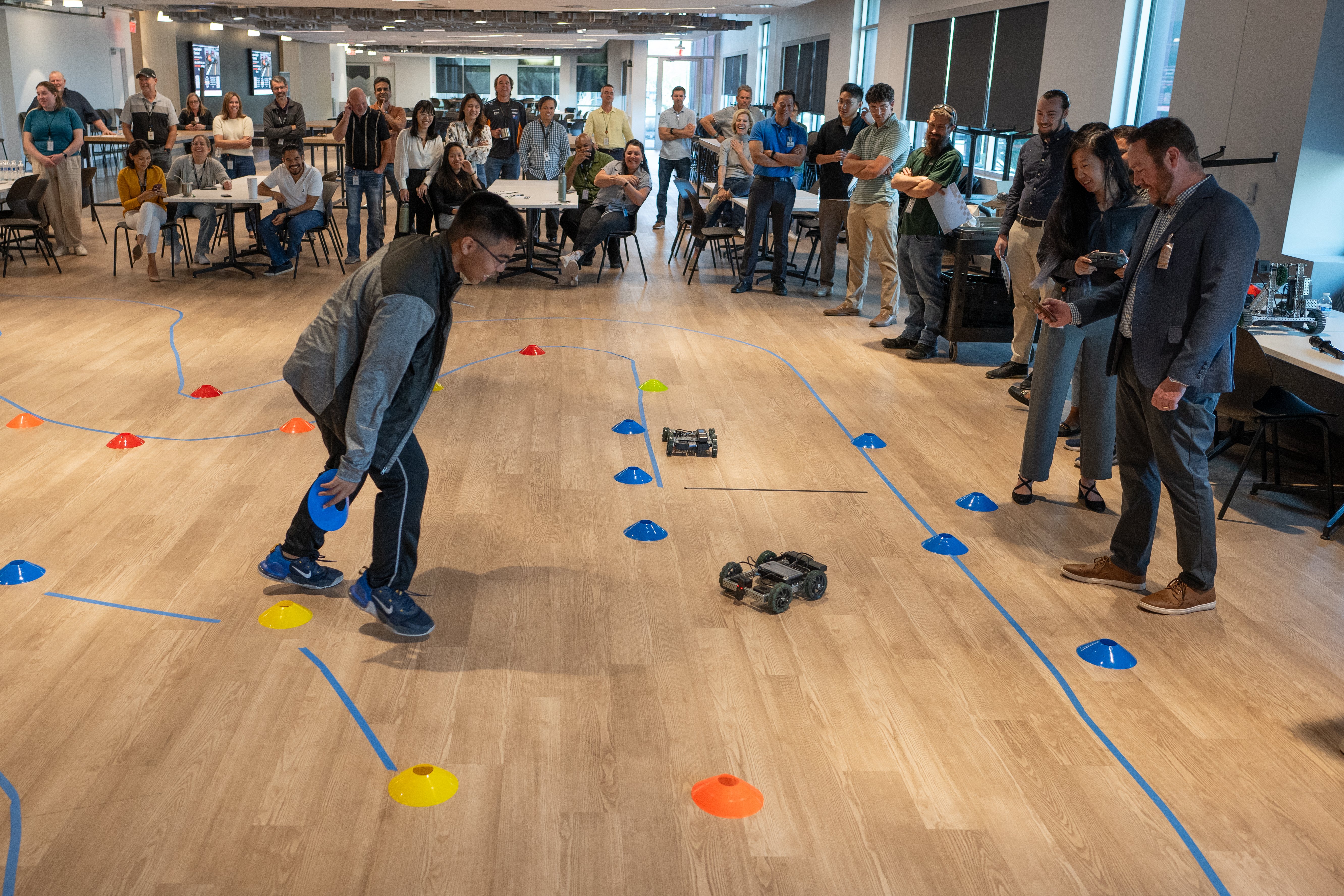 PLTW Engineering students and onsemi employees excitedly watch an RC car race