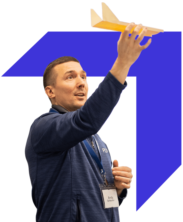 PLTW Training Facilitator demonstrating a project with wayfinder logo background accent