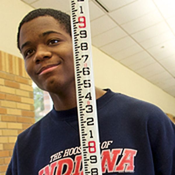 Engineering student holding a large ruler. 