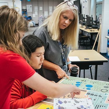 Teacher collaborating with PLTW Gateway students