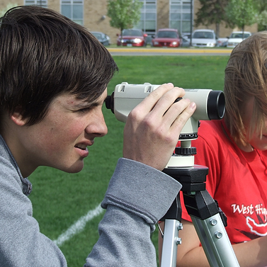 PLTW student looking through a telescope outside the classroom