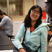 engineering student laughing & wearing safety glasses.